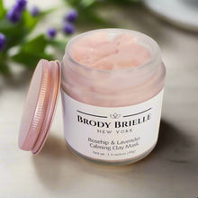 Load image into Gallery viewer, Open jar of Brody Brielle New York Rosehip & Lavender Calming Clay Mask on a light surface with blurred greenery in the background.