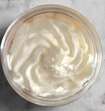 Load image into Gallery viewer, Close-up of a container filled with Brody Brielle whipped body butter on a marble surface