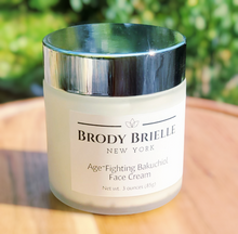 Load image into Gallery viewer, Jar of Brody Brielle New York Bakuchiol face cream outside on a wooden surface with a blurred green background
