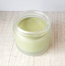 Load image into Gallery viewer, Glass jar with Brody Brielle French green clay cleansing balm inside on a light wooden surface
