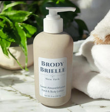 Load image into Gallery viewer, Bottle of Brody Brielle hand and body lotion on a marble surface with a plant and towel in the background.

